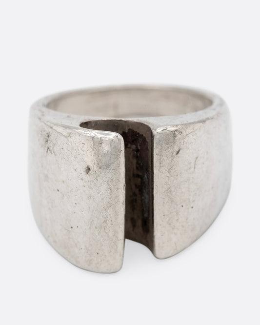 A silver ring with a notch in the front, shown from the front.