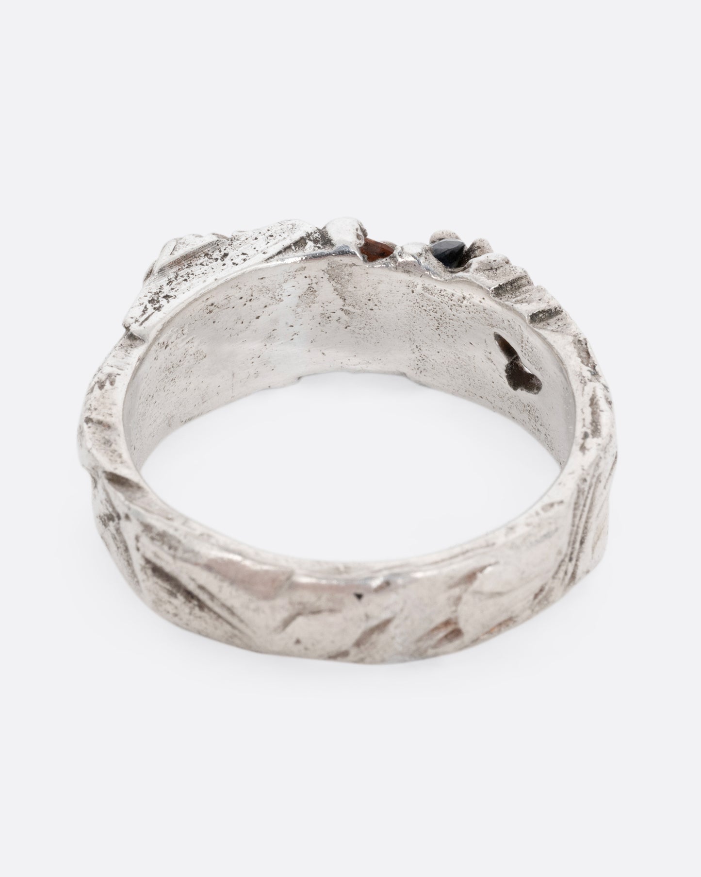 A silver ring with a citrine and amethyst embedded in it, shown from the back.