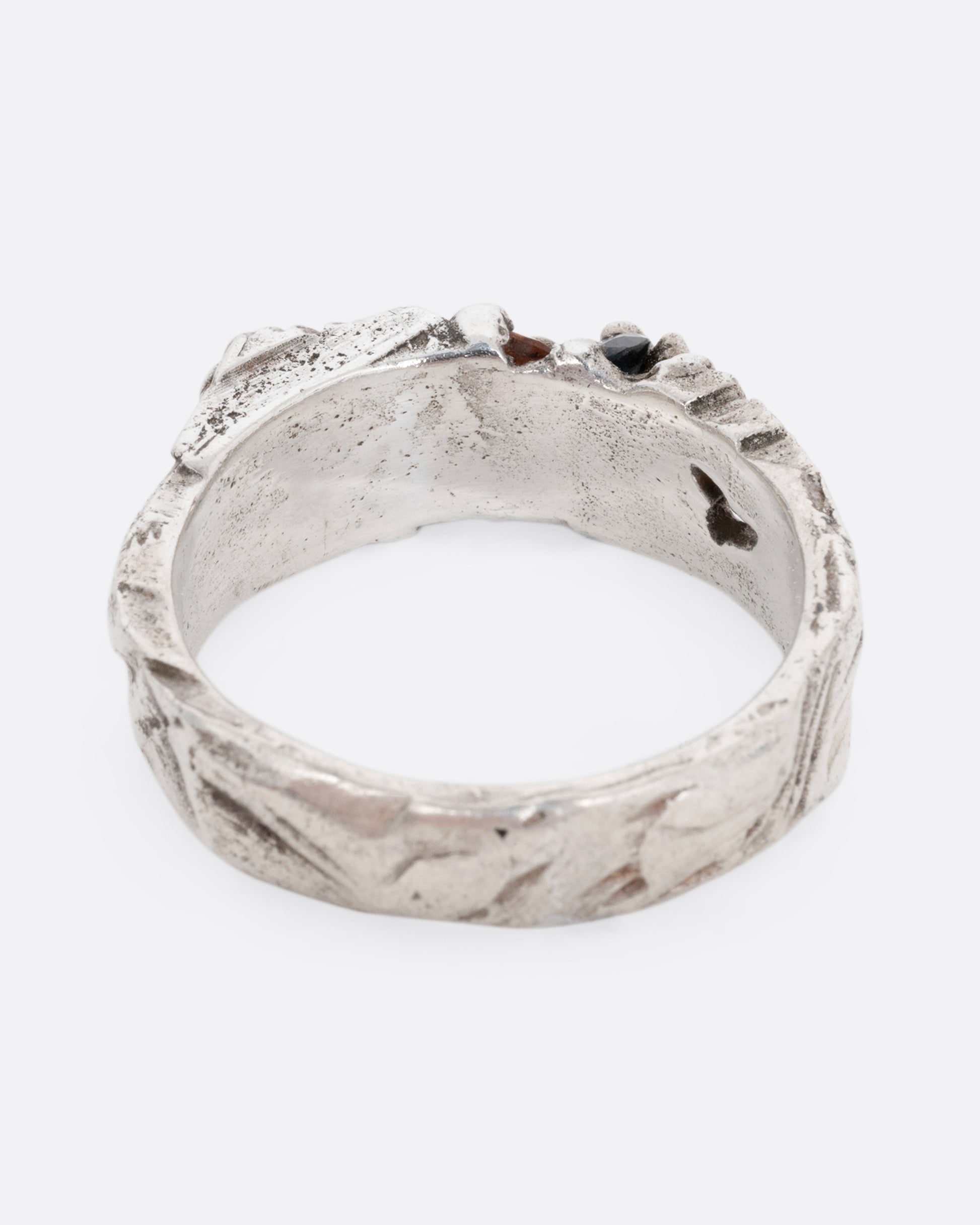 A silver ring with a citrine and amethyst embedded in it, shown from the back.