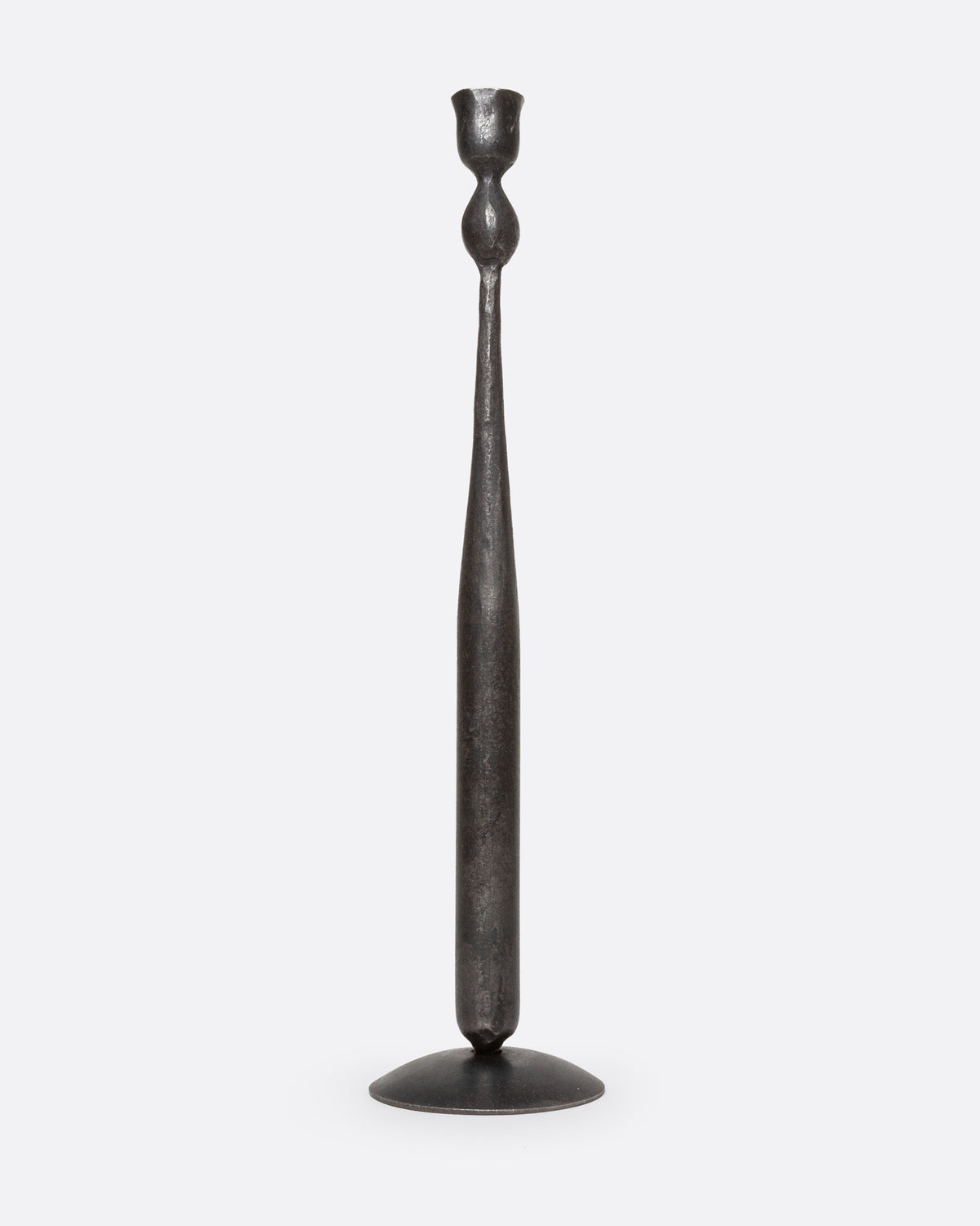 A tall, slender iron candlestick holder with  a flared circular base, shown from the front.