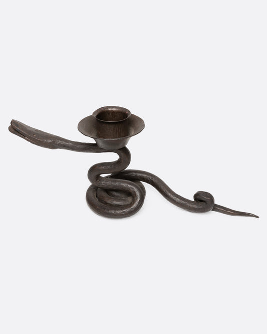 An iron coiling iron snake candle holder, shown from the side.