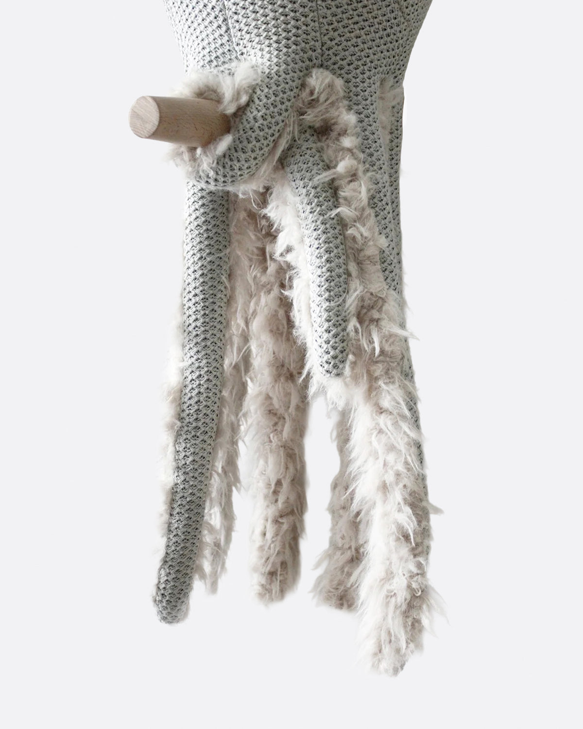 Close-up of the octopus's fluffy tentacles and a small wooden cane.