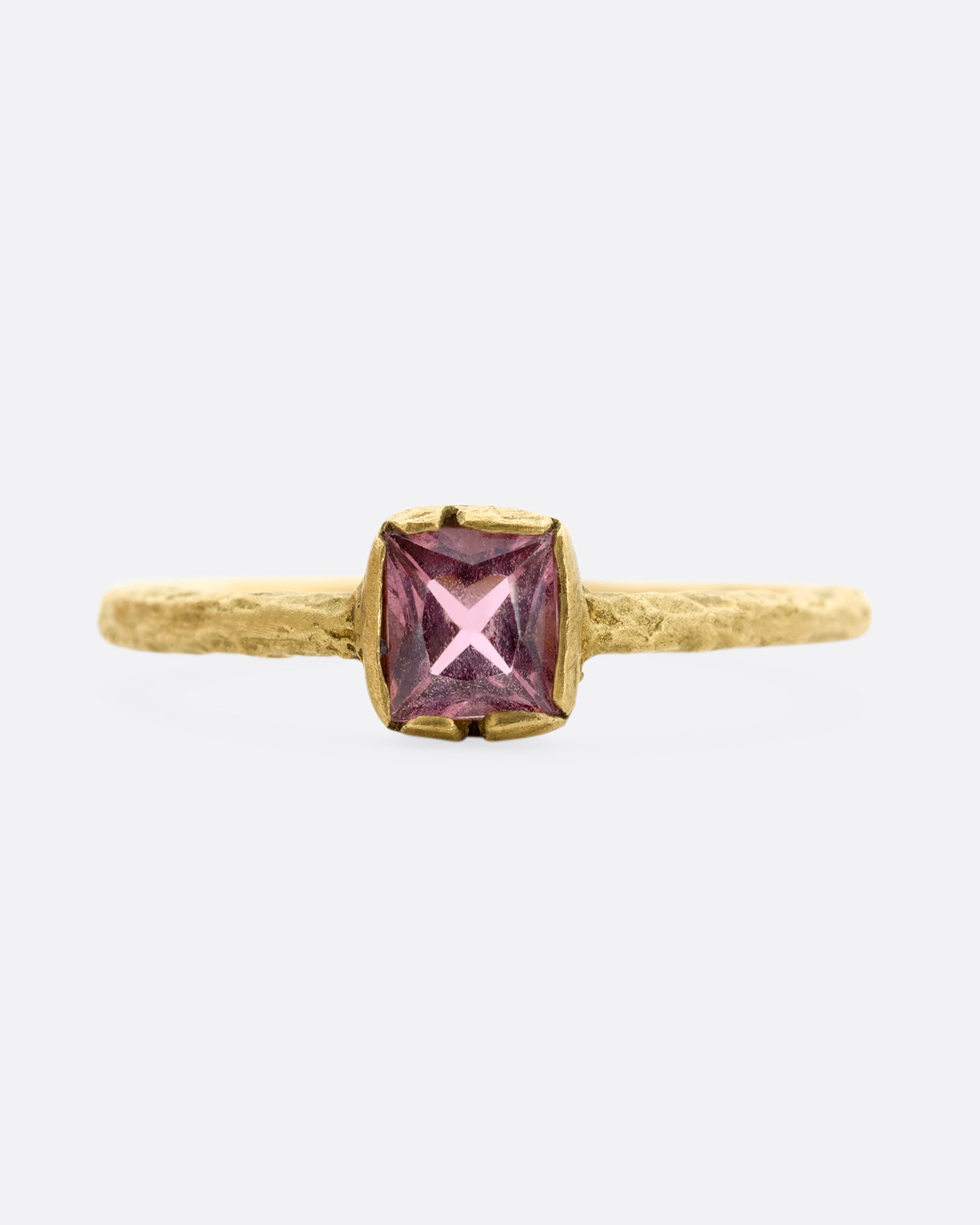 A textured yellow gold ring with a square pink tourmaline. Shown from the front.