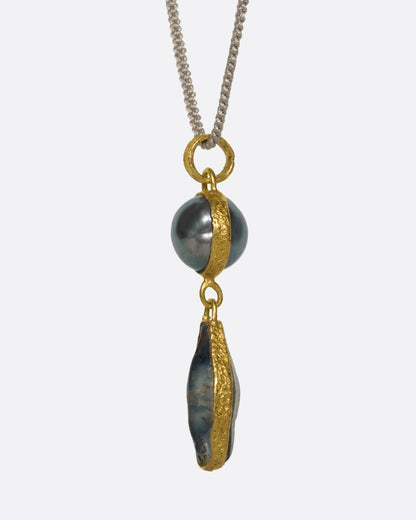 Yellow gold Tahitian pearl and sapphire pendant necklace, side view showing the textured gold wrapping the pearl and sapphire
