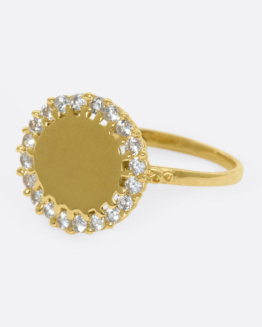 A 14k gold circle ring with a white diamond halo