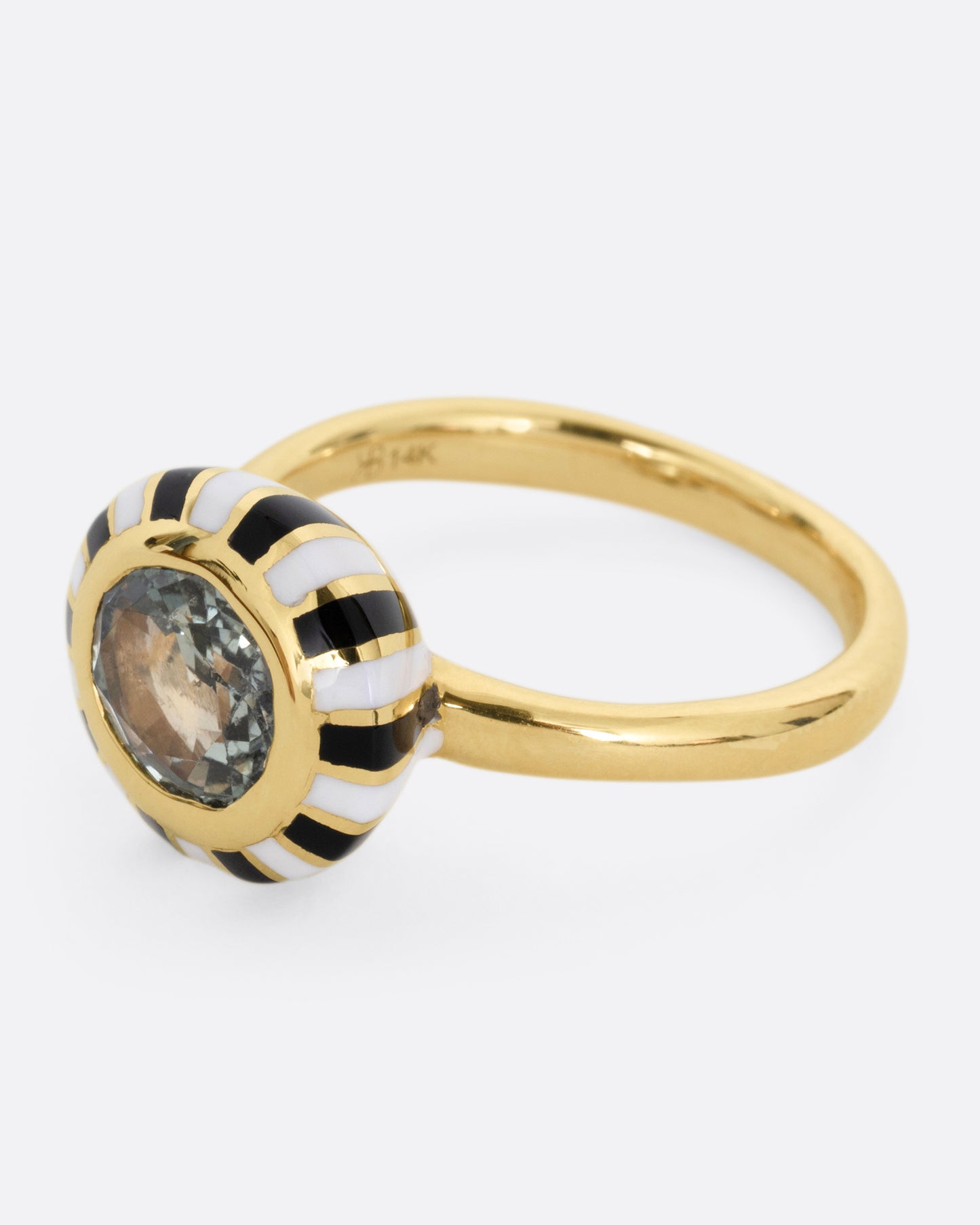 A yellow gold ring with an enamel checkerboard pattern around a green sapphire, shown from the side.