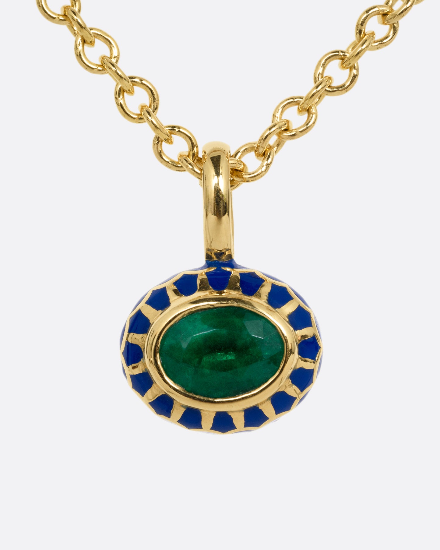 A yellow gold cable chain necklace with a pendant with a blue enamel pattern around an emerald. The pendant has a domed silhouette and floral enamel motif on its reverse. Shown from the front.