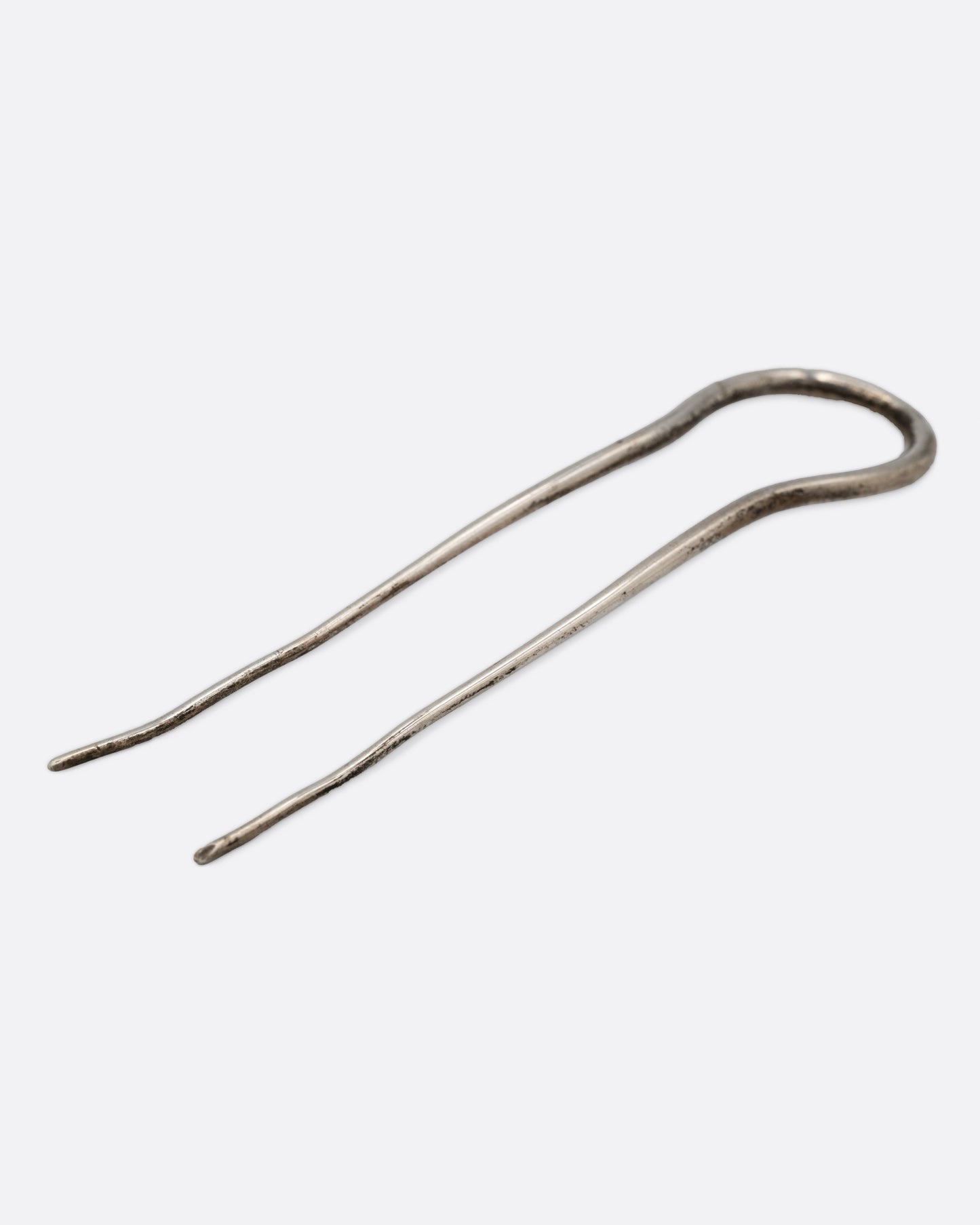 A silver hair pin with an arch at the top, shown lying flat.