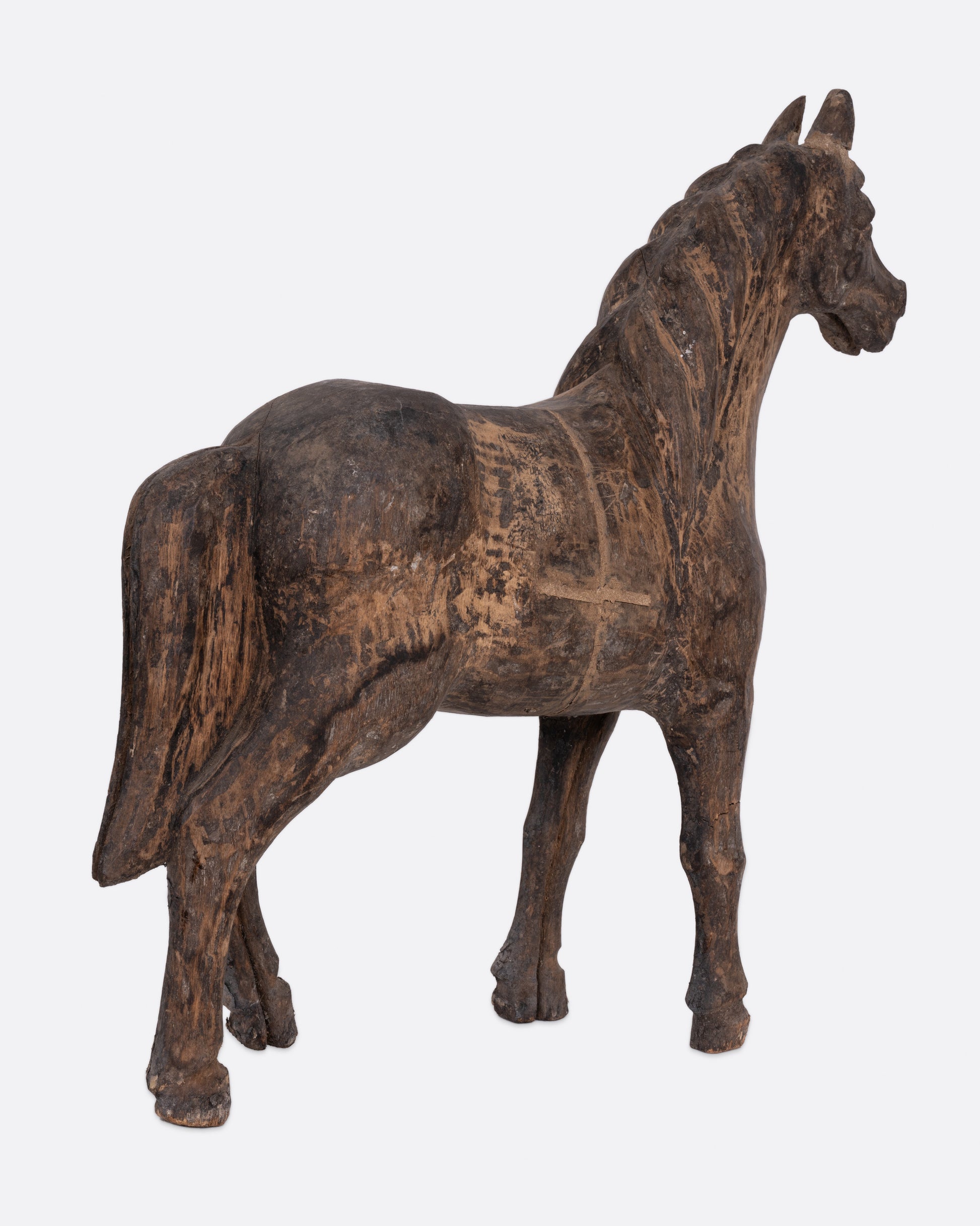 A wooden horse  takaan sculpture shown from the back.