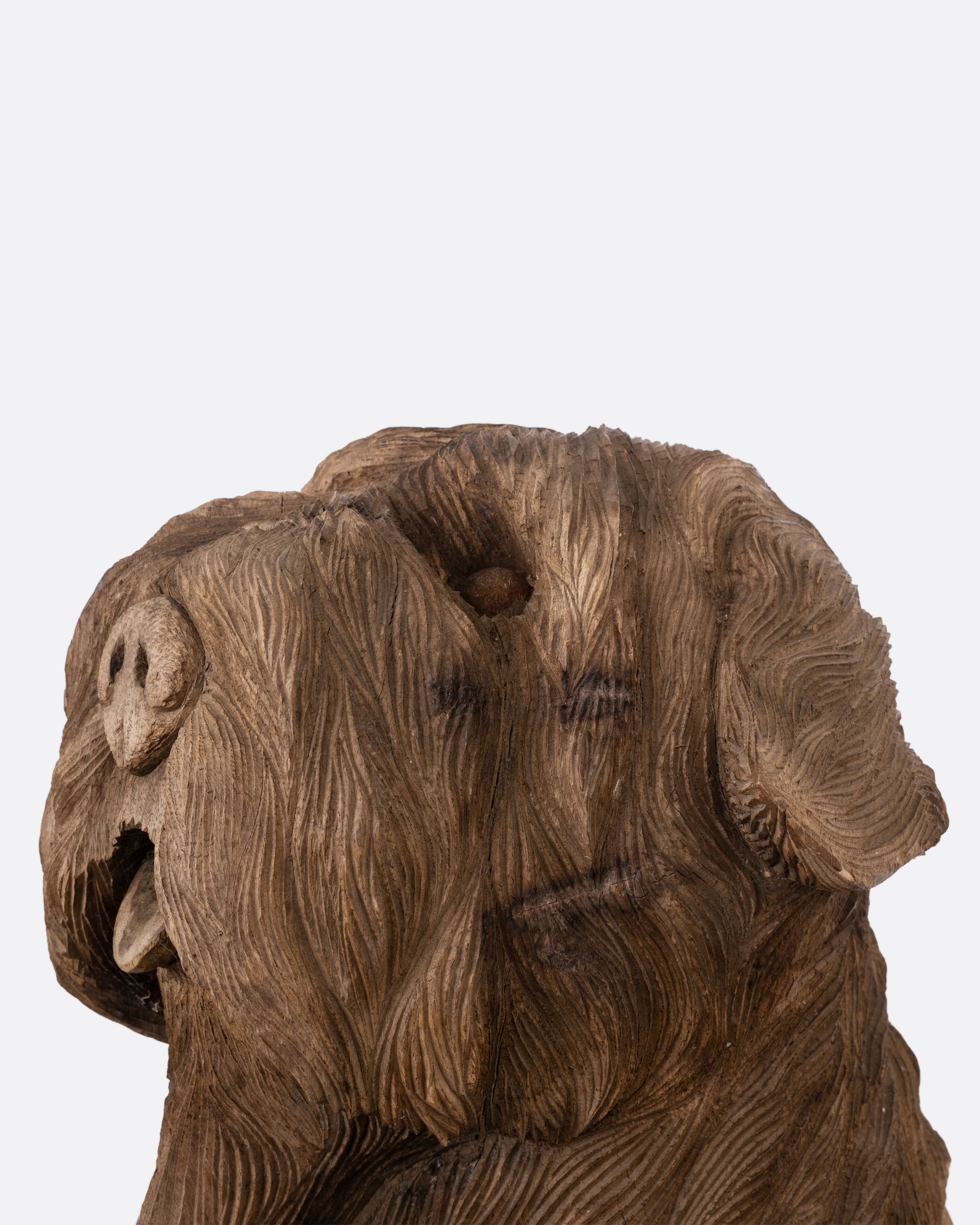 A wooden dog takaan sculpture shown from the side.