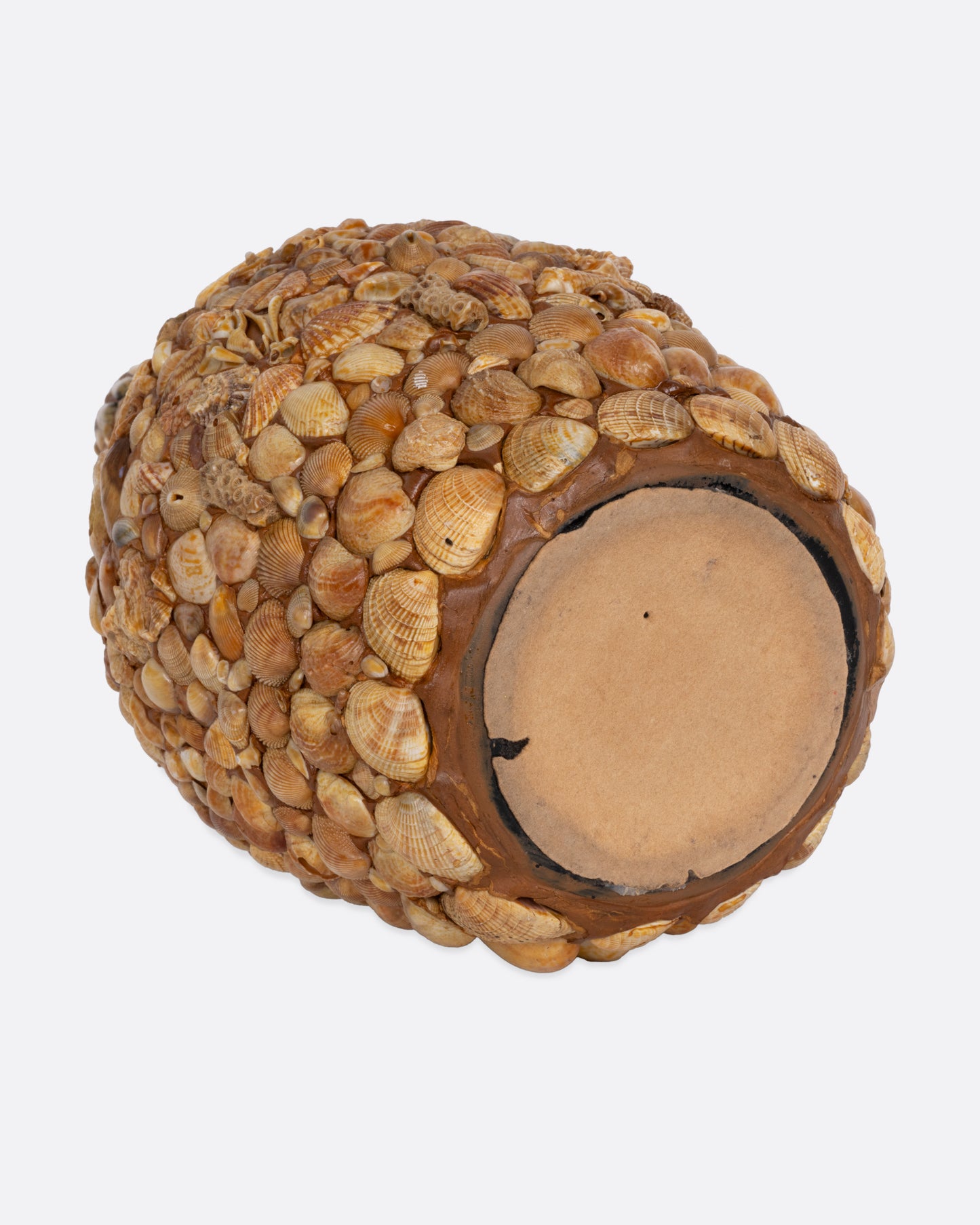 A bottle covered in shells to create a mosaic, shown from the bottom.