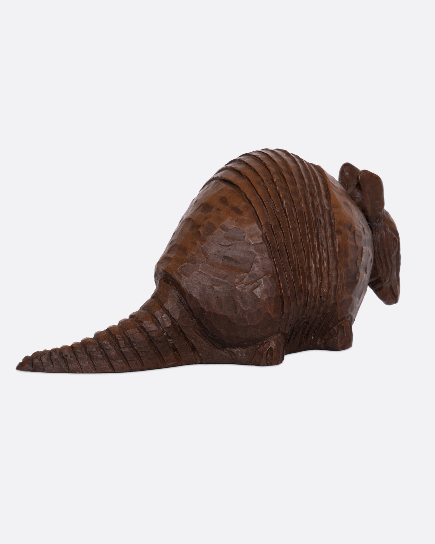 A wooden armadillo sculpture shown from the back.