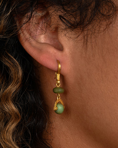 Yellow gold jade stirrup drop earrings worn on an ear