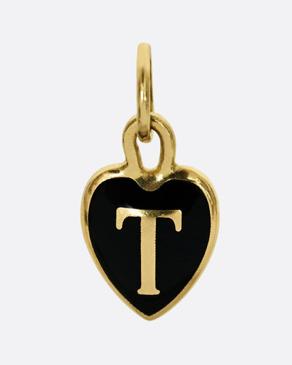 A yellow gold heart shaped charm with black enamel and a letter T. Shown from the front.