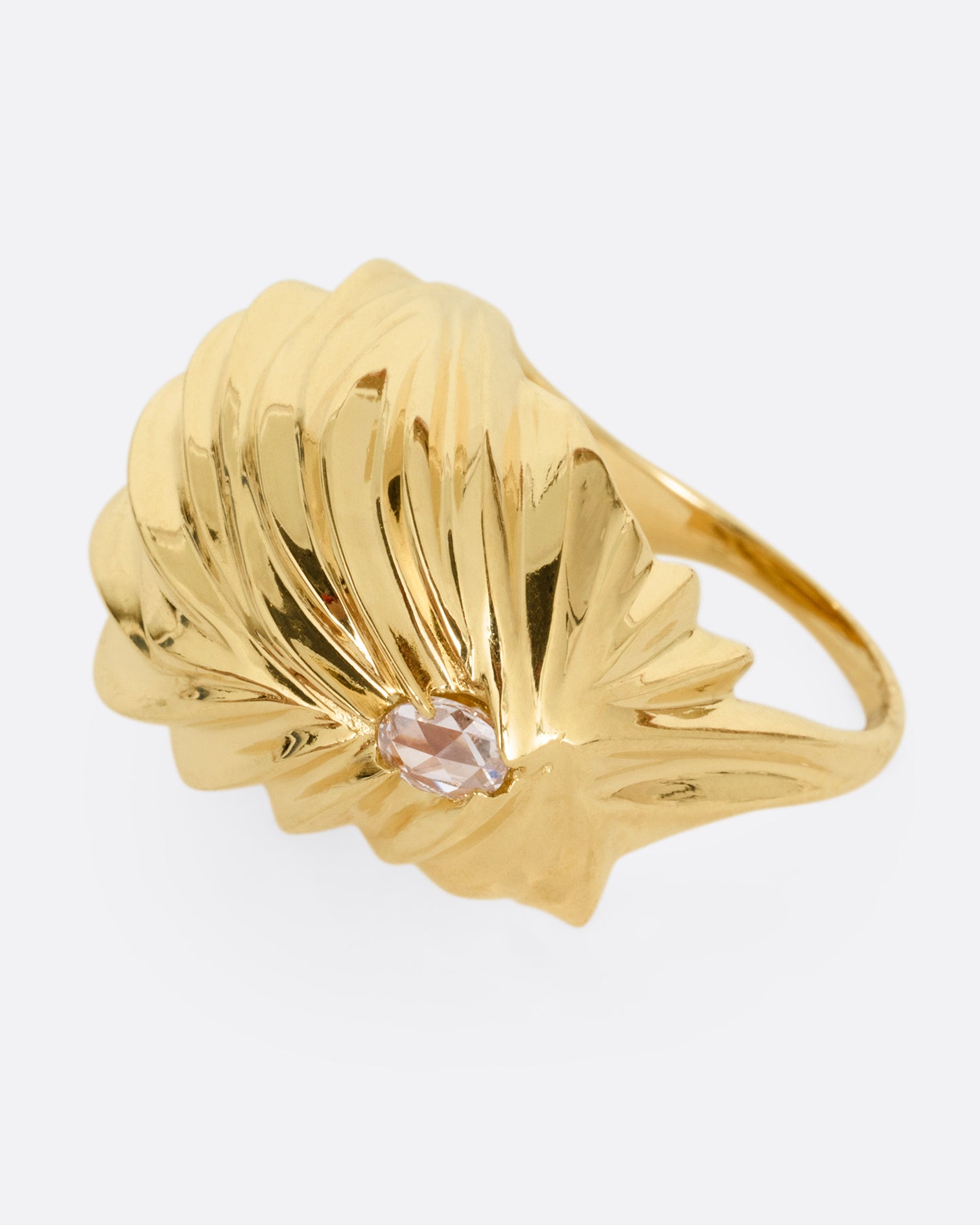 A yellow gold textural dome ring with a rose cut diamond, shown from the side.