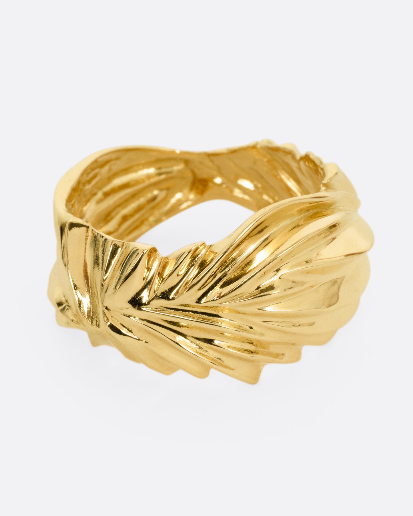 A yellow gold ring with wavy and chevron textures, shown from the side.