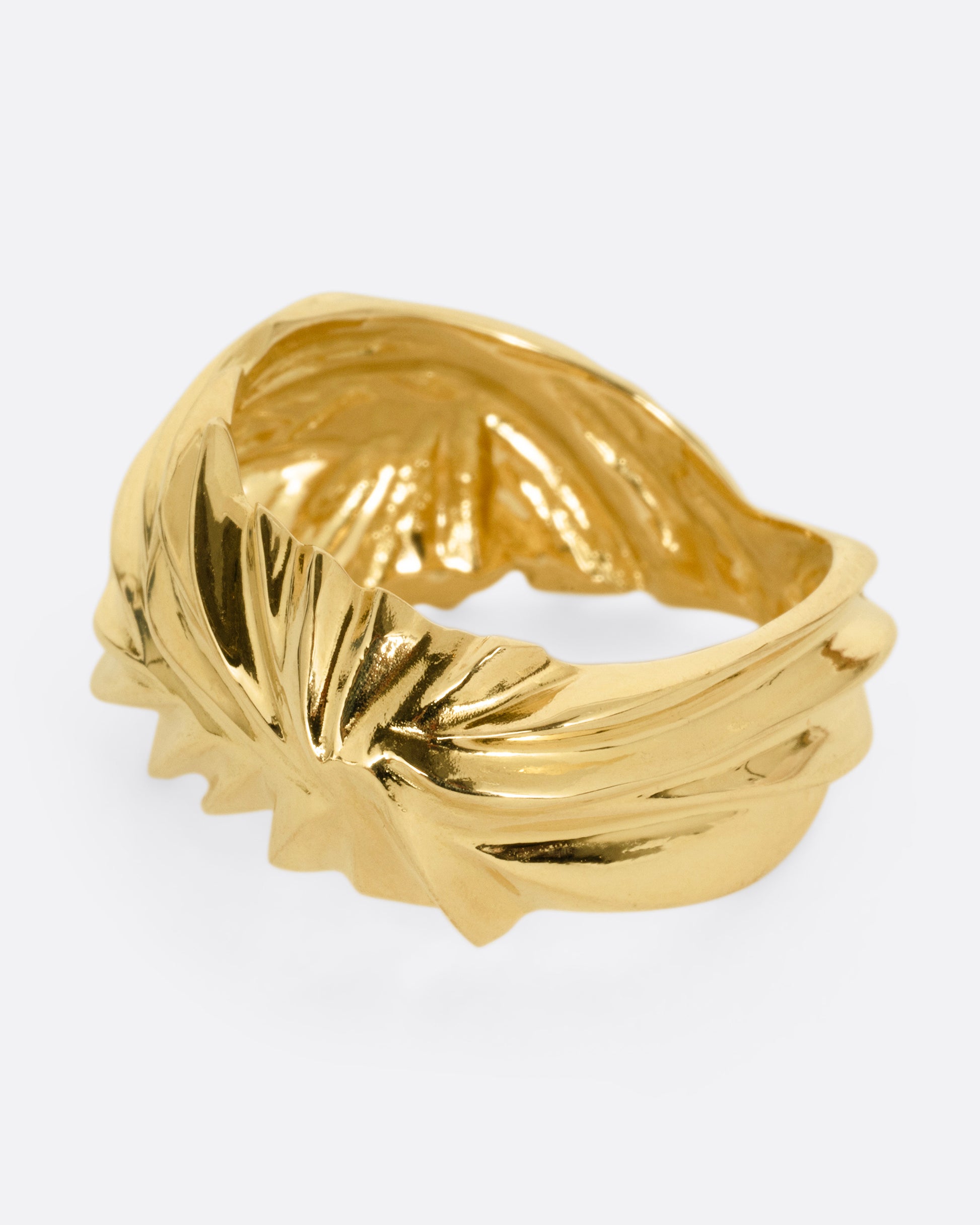 A yellow gold ring with wavy and chevron textures, shown from the side.