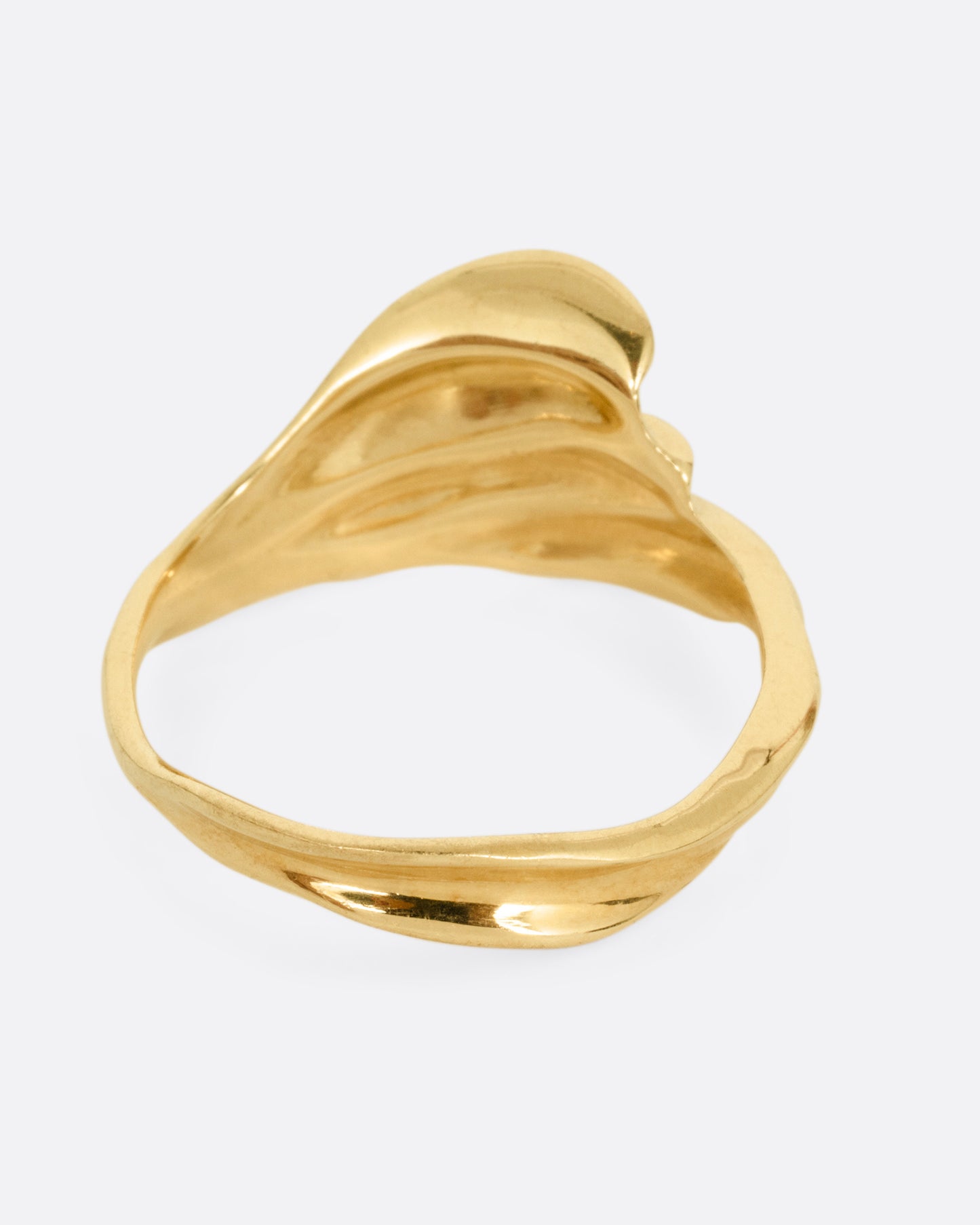 A yellow gold ring with a fluid, dimensional silhouette and narrow back, shown from the back.