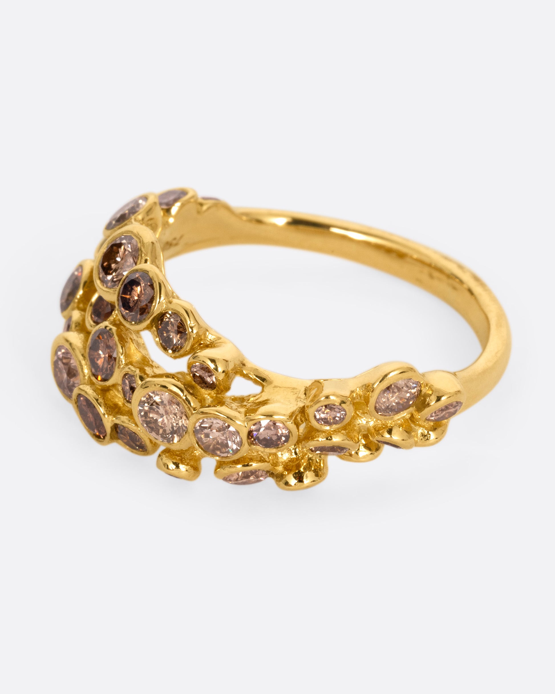 A yellow gold ring with layers of cognac diamonds, shown from the side.