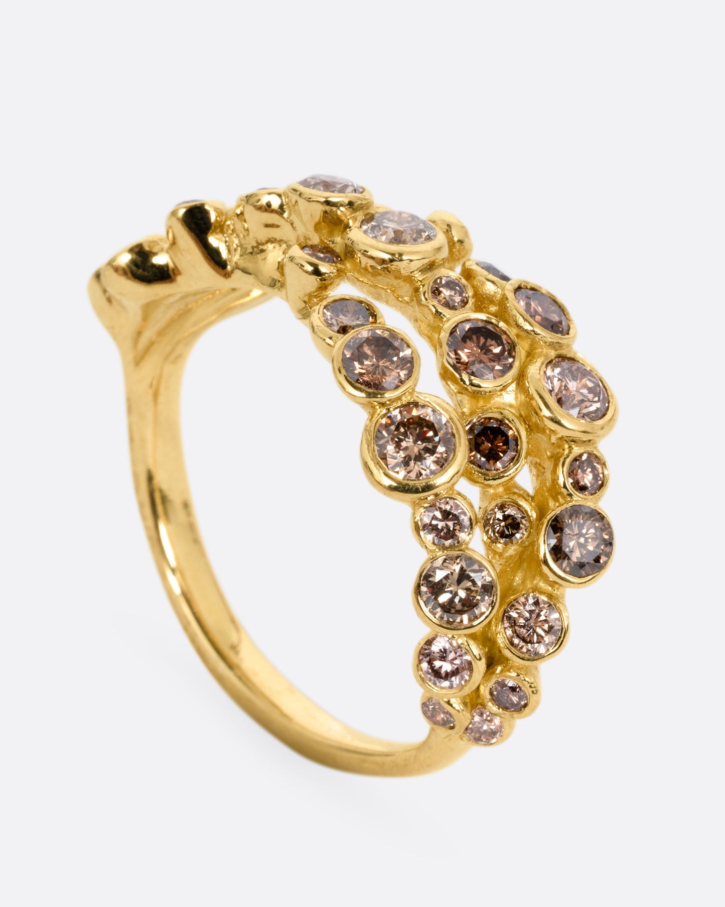 A yellow gold ring with layers of cognac diamonds, shown from the side standing up.