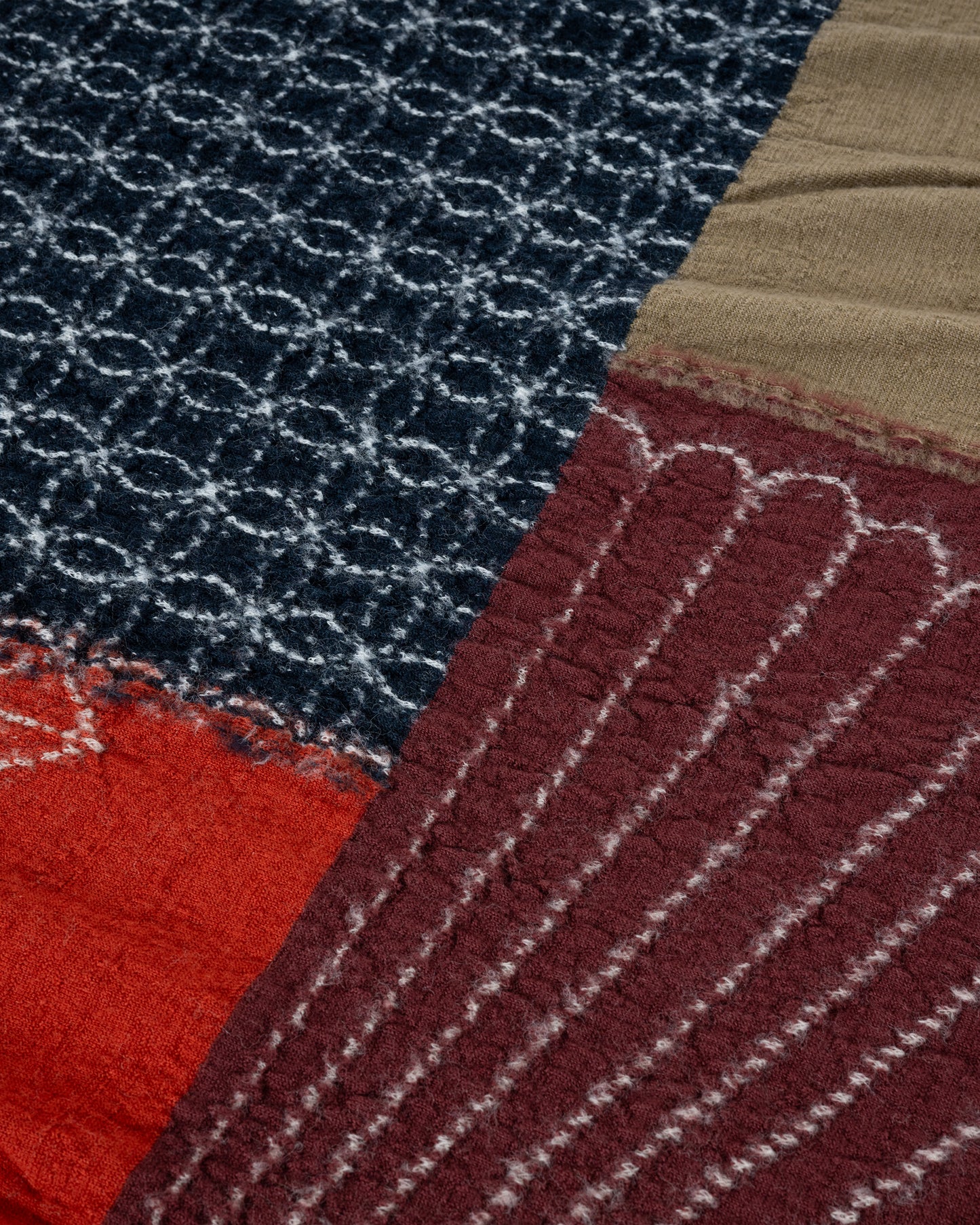 A red patchwork wool scarf. Close up of pattern.