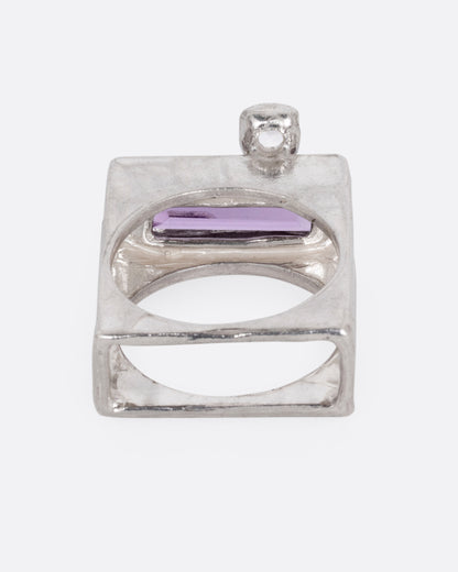 A silver square ring with an amethyst baguette and two square topaz, shown from the back.