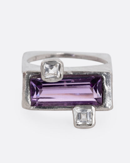 A silver square ring with an amethyst baguette and two square topaz, shown from the front.