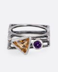 A silver stacked square ring with a triangular citrine and round amethyst, shown from the front.
