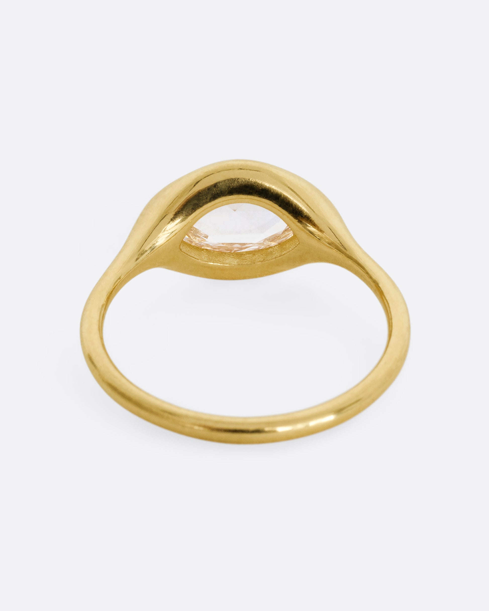 A yellow gold ring with a horizontal rose cut marquise diamond. Shown from the back.
