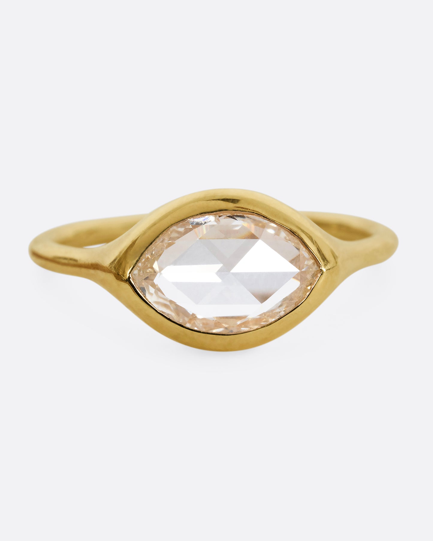 A yellow gold ring with a horizontal rose cut marquise diamond. Shown from the front.