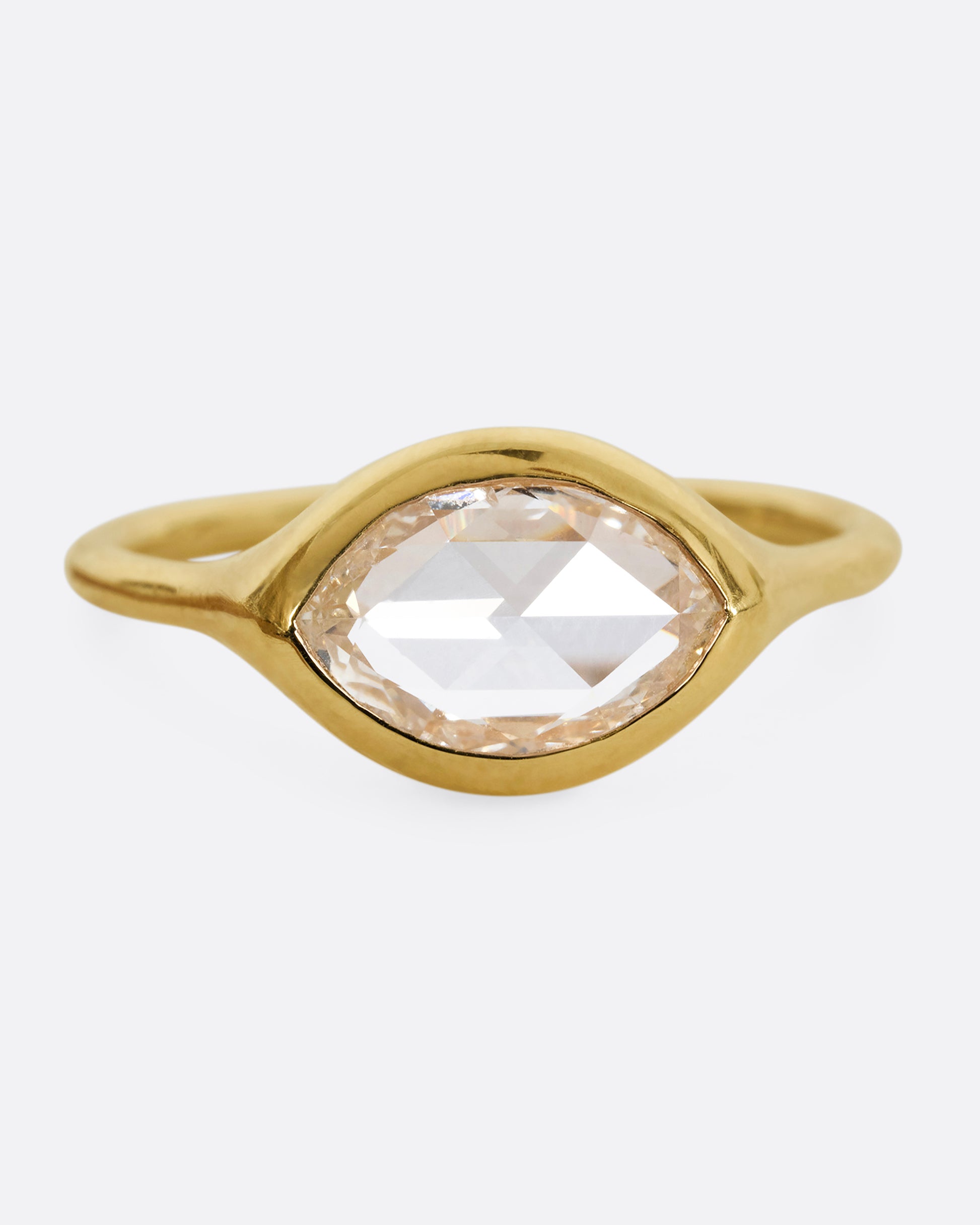 A yellow gold ring with a horizontal rose cut marquise diamond. Shown from the front.