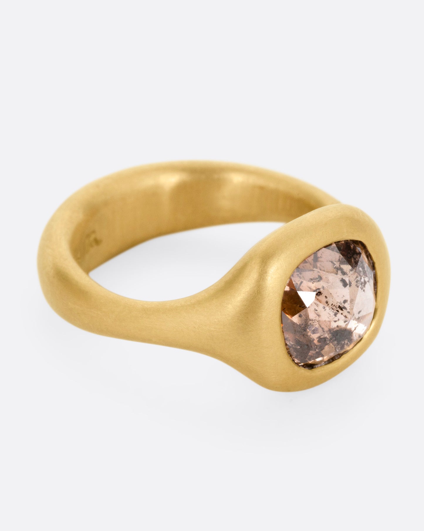 A yellow gold ring with a cognac diamond, shown from the front.
