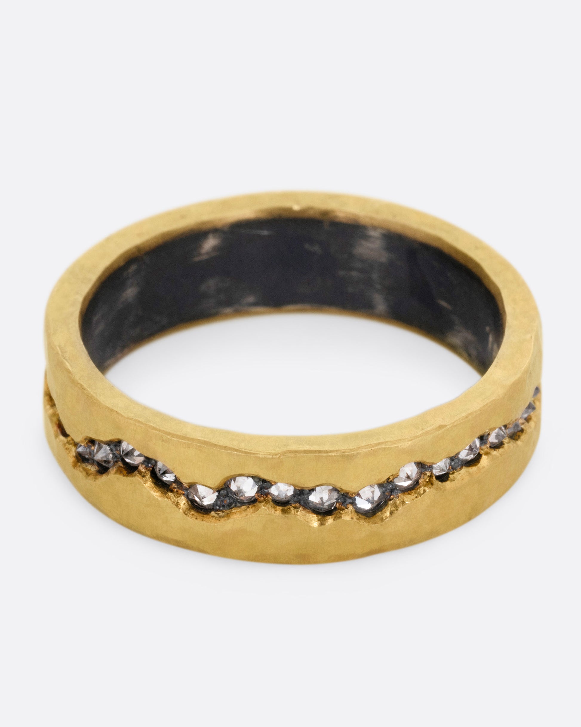 An oxidized silver ring with a yellow gold hammered finish and a fissure filled with inverted diamonds, shown from the front.