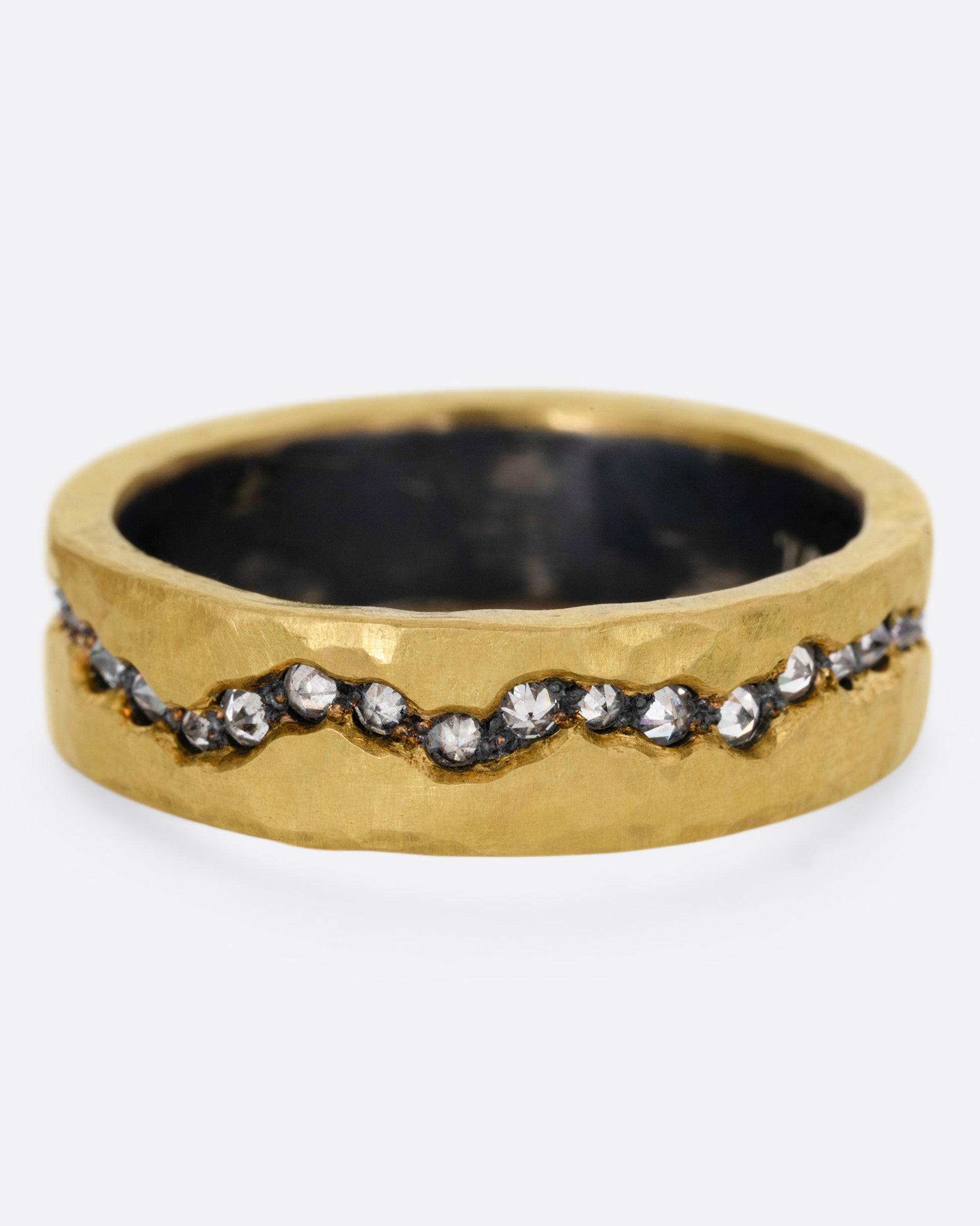 An oxidized silver ring with a yellow gold hammered finish and a fissure filled with inverted diamonds, shown from the front.