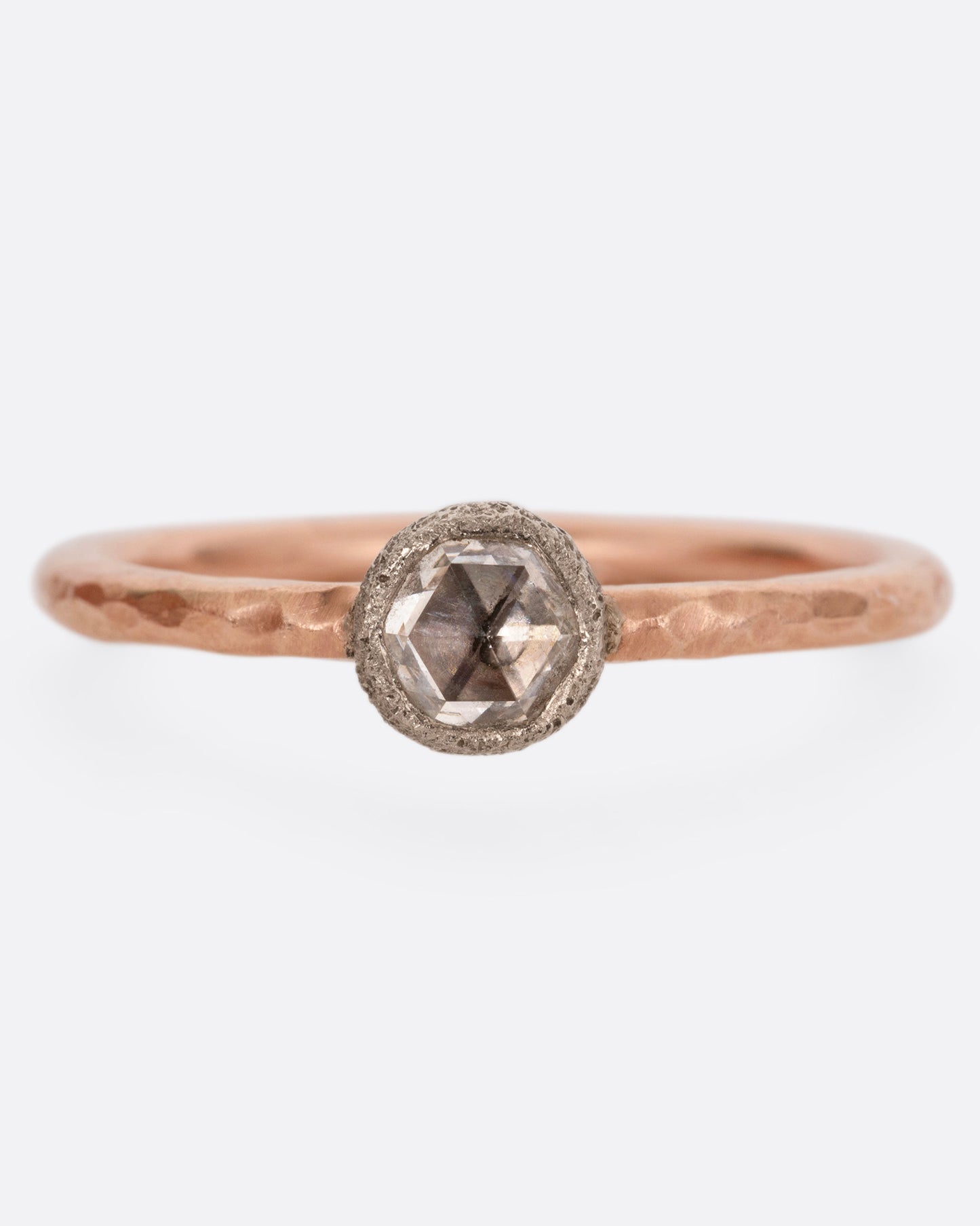 A rose gold ring with a diamond, shown from the front.