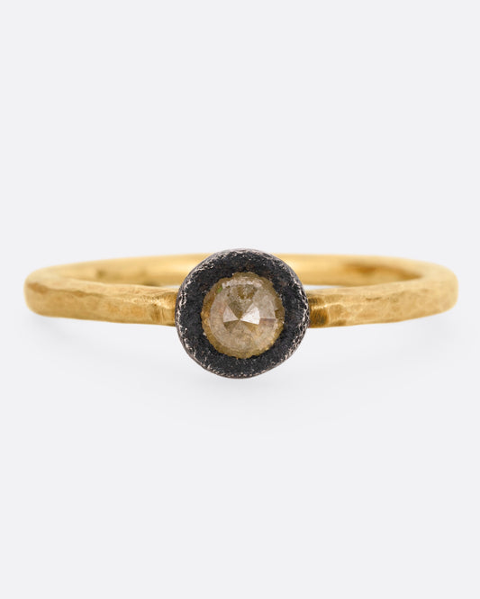 A yellow gold ring with a darkened sterling bezel and a yellow diamond, shown from the front.