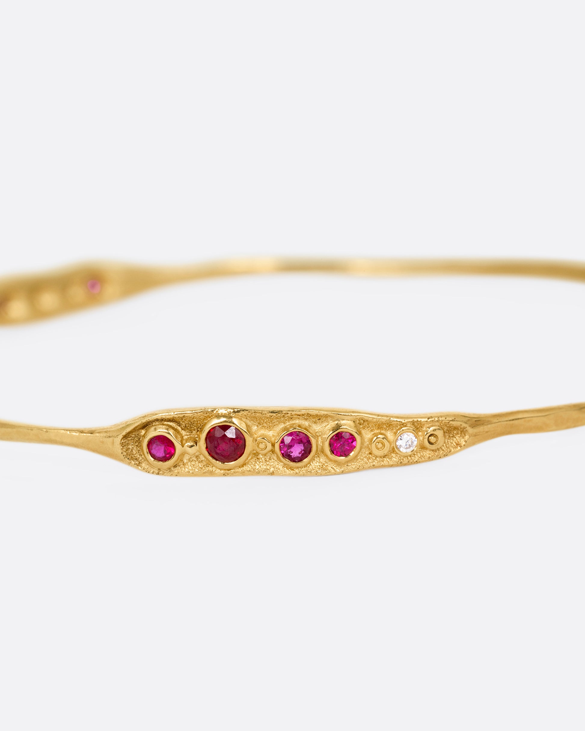 A yellow gold bracelet with rubies and diamonds, shown from the front.