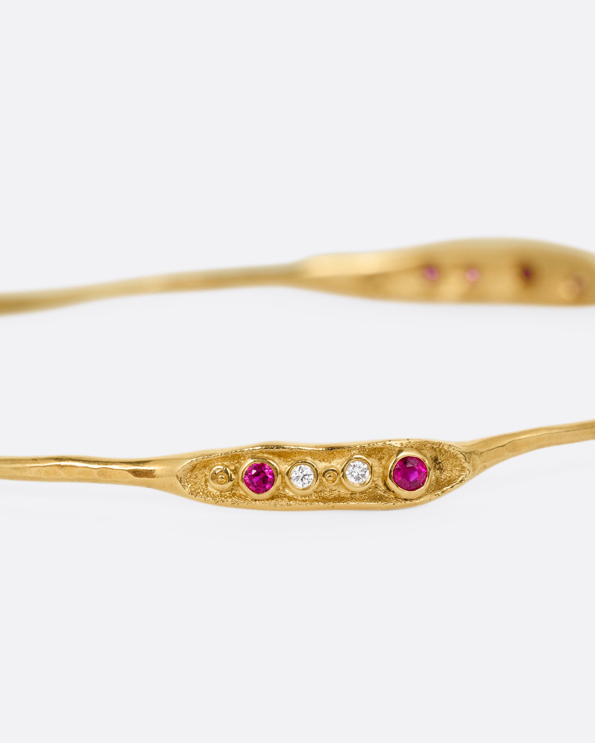 A yellow gold bracelet with rubies and diamonds, shown from the front.