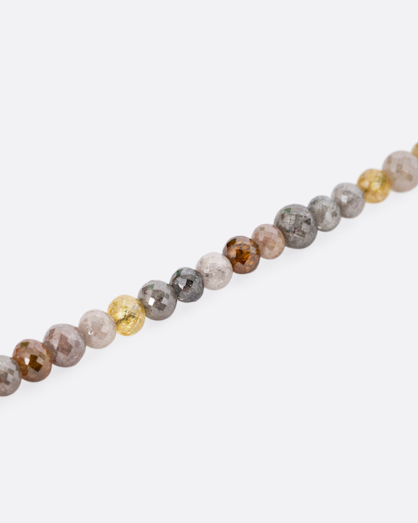 A close up of a multicolored diamond beaded necklace with a yellow gold charm holder.
