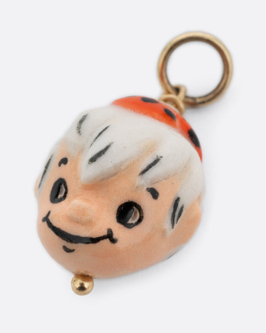 A yellow gold pendant with a porcelain Bamm-Bamm Rubble, shown from the front.