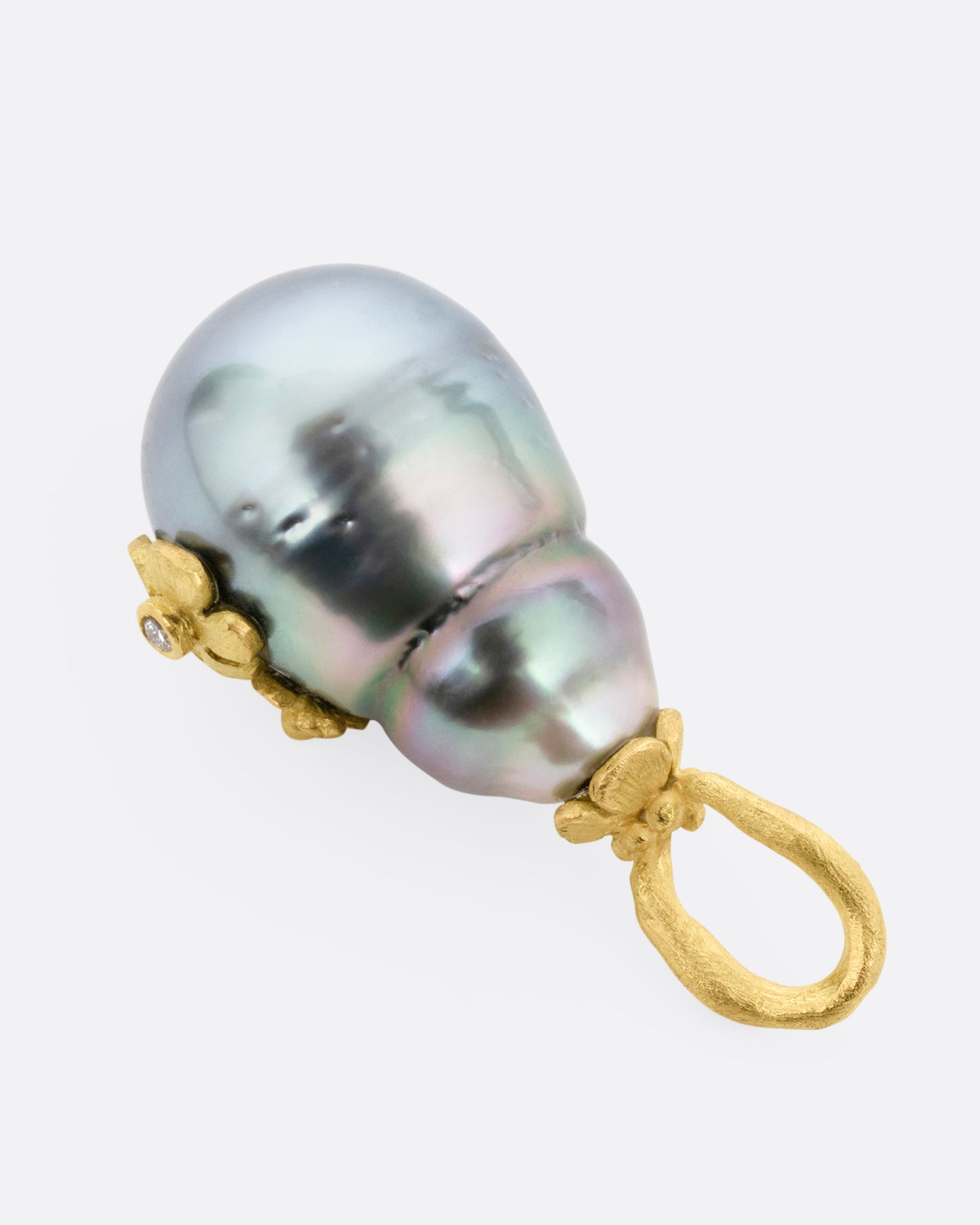 A yellow gold  Tahitian pearl pendant with diamond accented flower details, shown from the back.