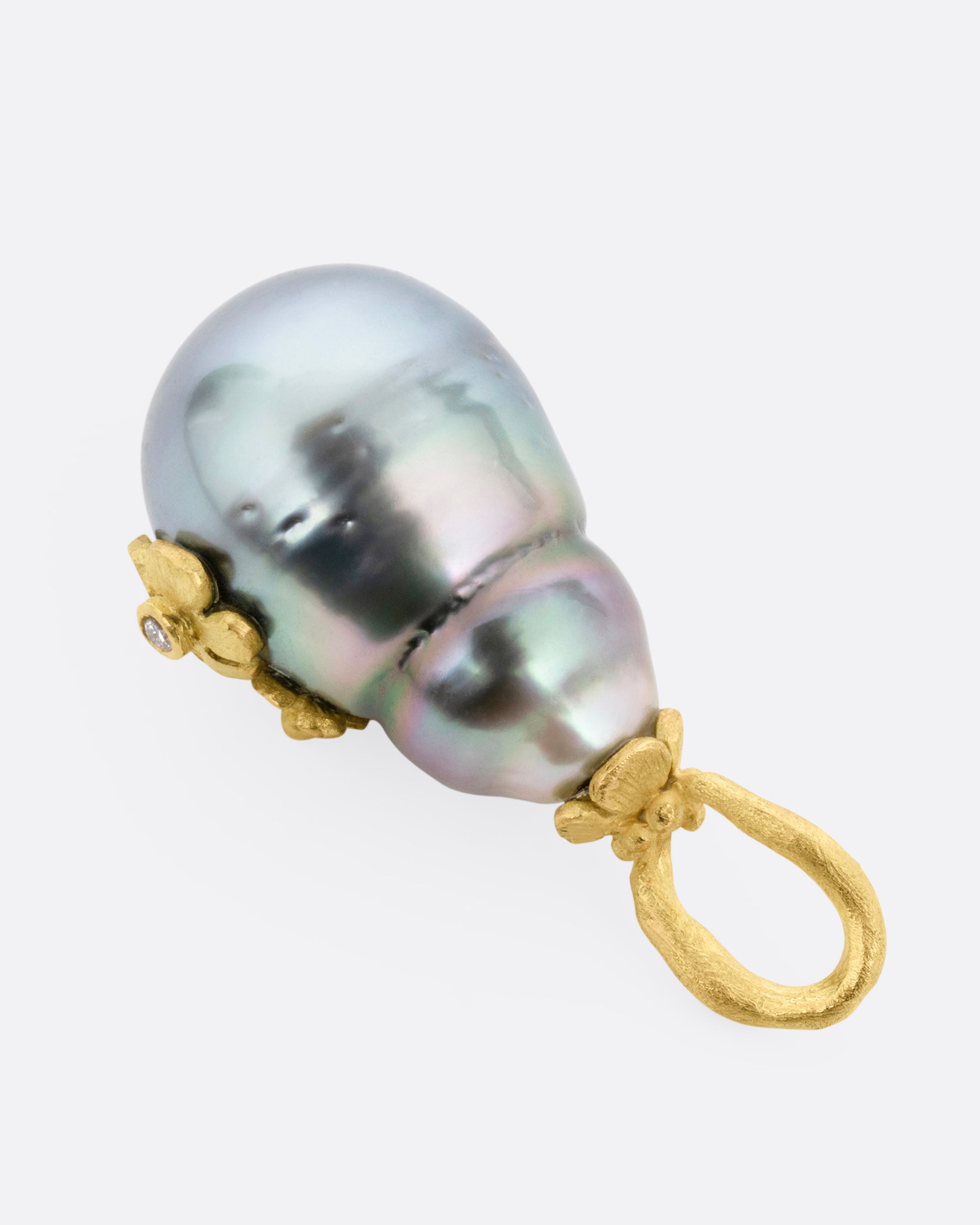 A yellow gold  Tahitian pearl pendant with diamond accented flower details, shown from the back.