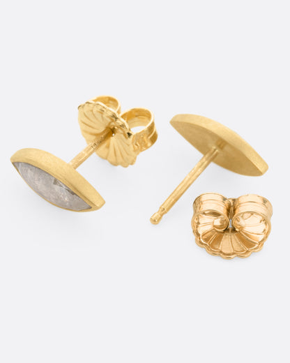 Yellow gold gray navette diamond stud earrings, the pair laid flat showing the posts and backs