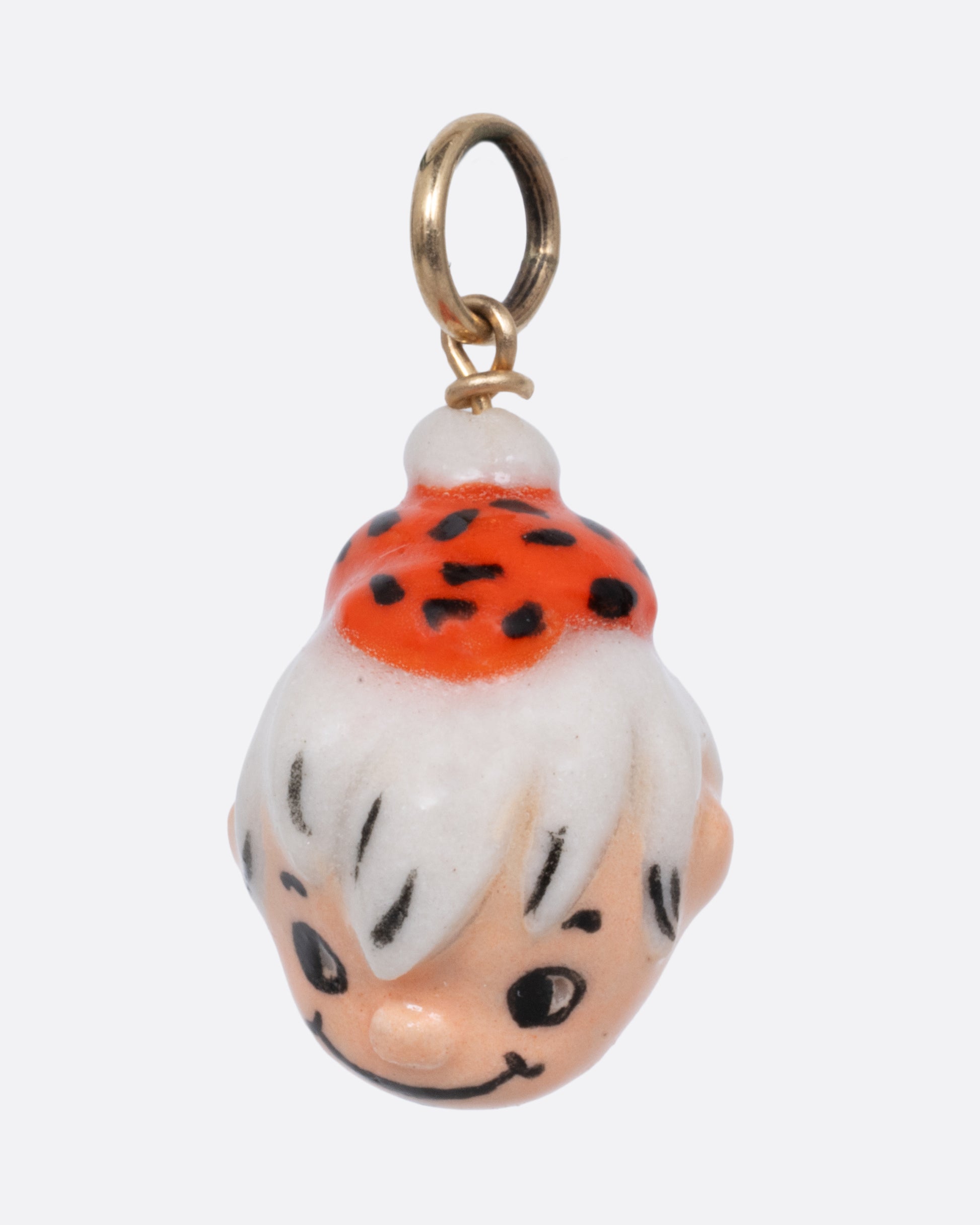 A yellow gold pendant with a porcelain Bamm-Bamm Rubble, shown from the side.