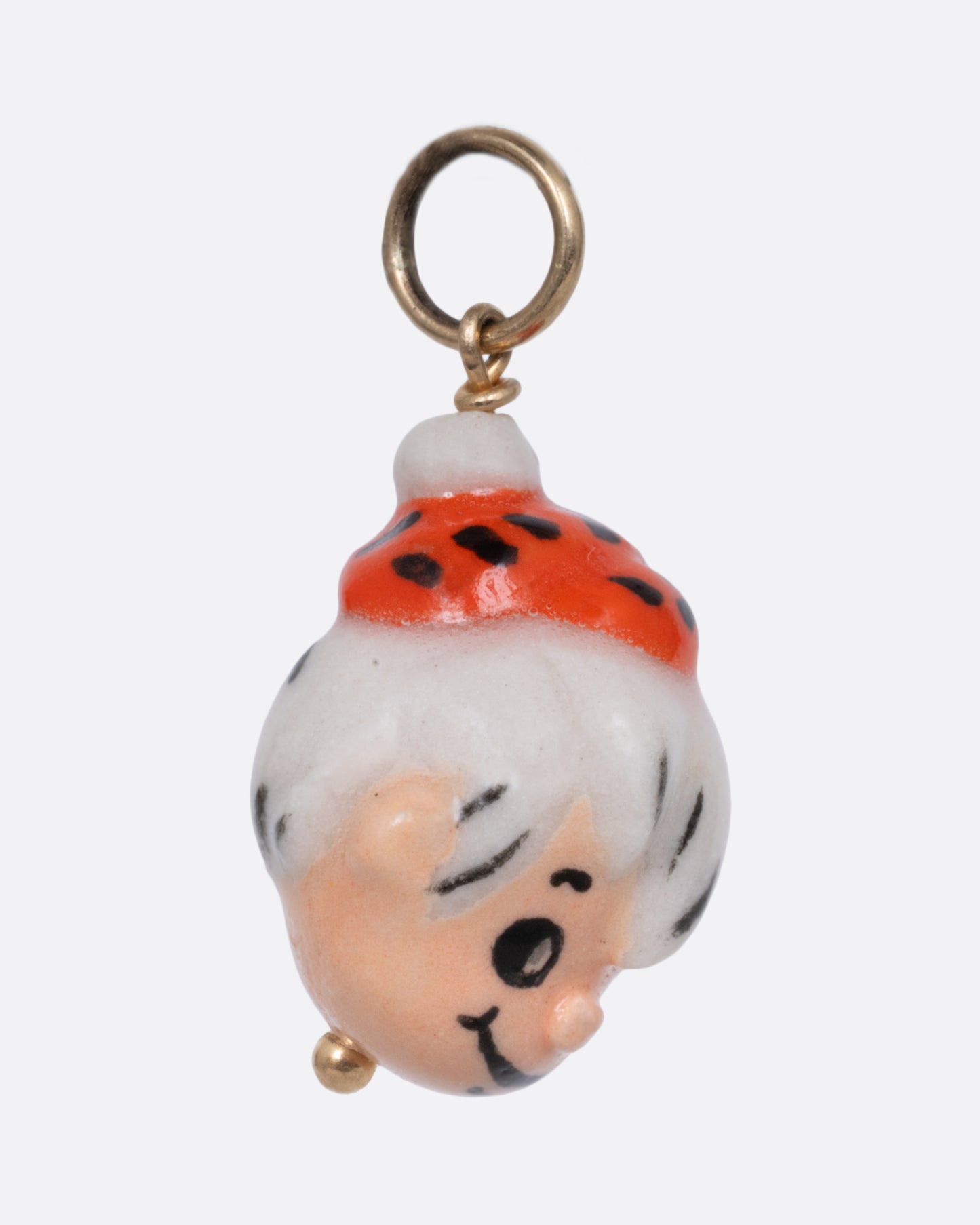 A yellow gold pendant with a porcelain Bamm-Bamm Rubble, shown from the side.