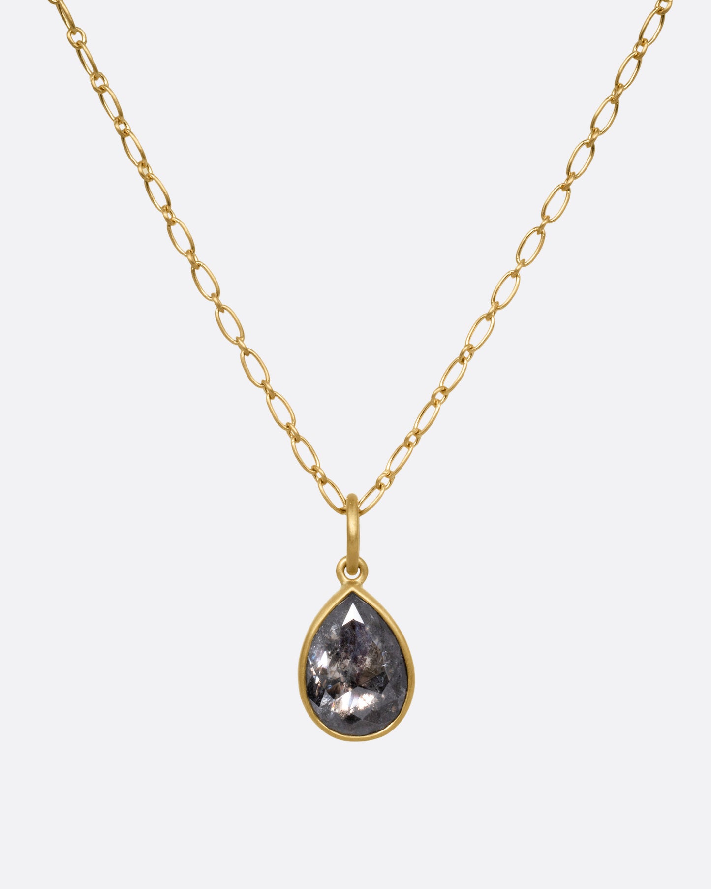 A yellow gold elongated link cable chain necklace with a teardrop shaped salt and pepper diamond, shown from the front.