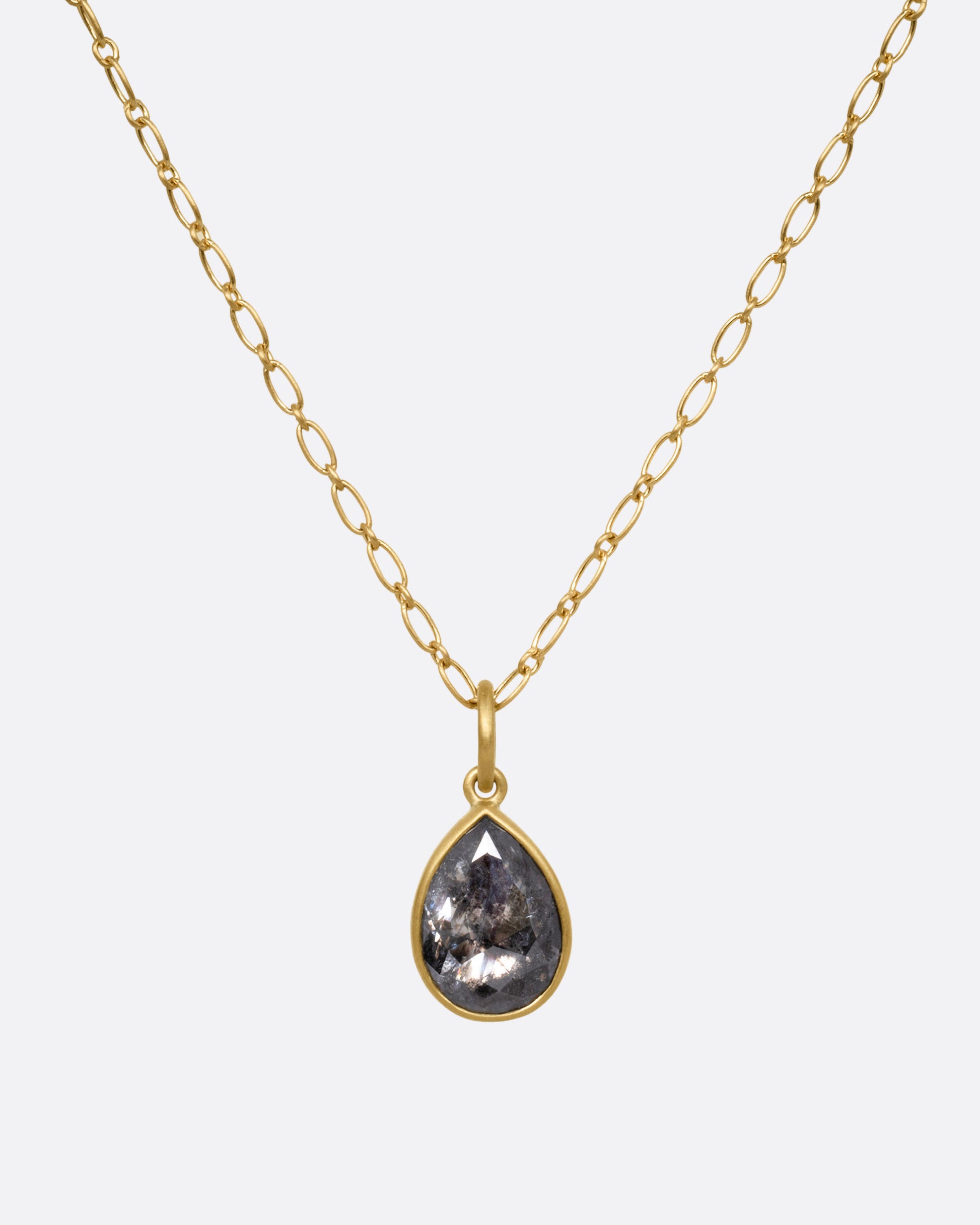 A yellow gold elongated link cable chain necklace with a teardrop shaped salt and pepper diamond, shown from the front.