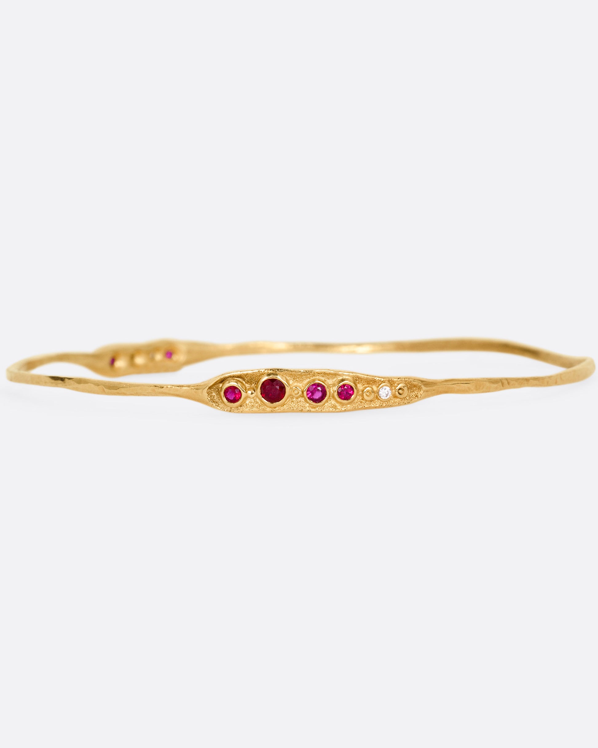 A yellow gold bracelet with rubies and diamonds, shown from the front.