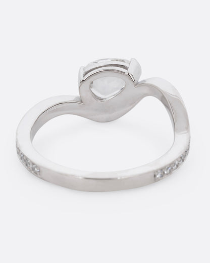 A diamond studded platinum ring with a wavy silhouette and a pear shaped rose cut diamond, shown from the back. 