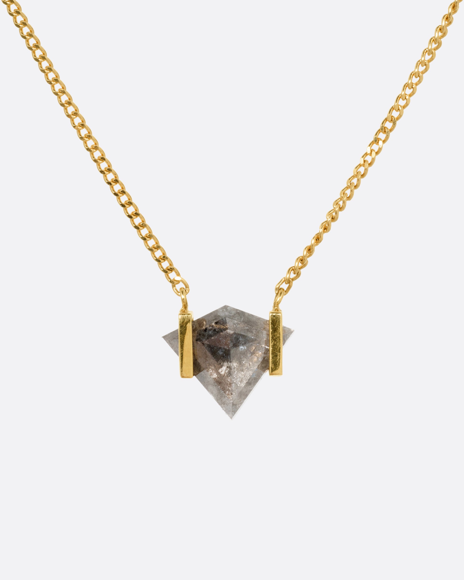 A yellow gold necklace with a salt and pepper diamond pendant, shown from the front.